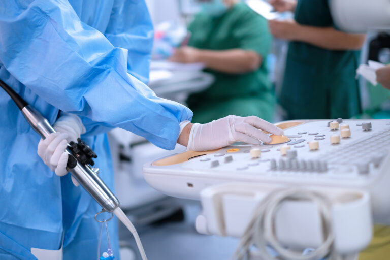 Cardiologist holding transesophageal ultrasound probe and use echocardiogram to assessment patient’s heart in cardiac operating room